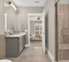 Modern bathroom with a glass shower, gray vanity, large mirror, and view into a bedroom with a ceiling fan and window.